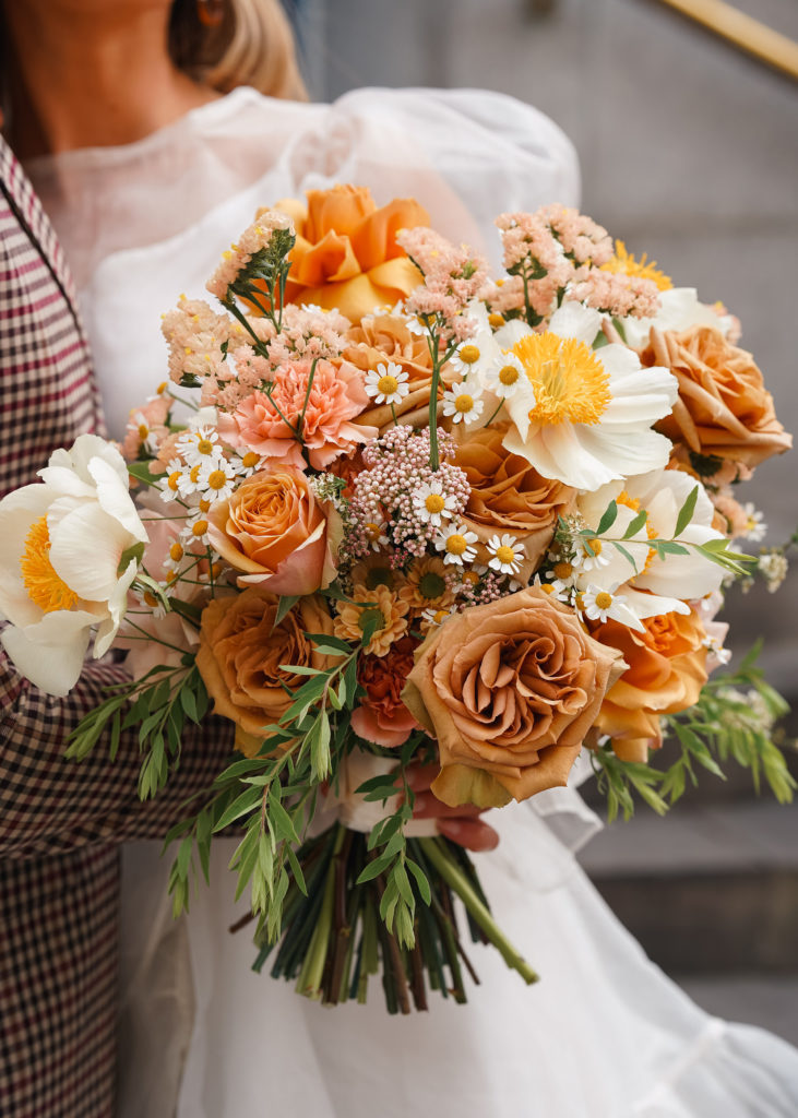 Close up of orange and white modern bouquet for bride