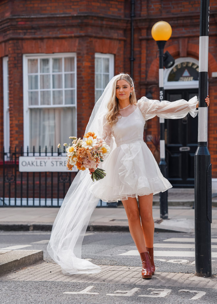 modern bride in short dress crosses street at london wedding