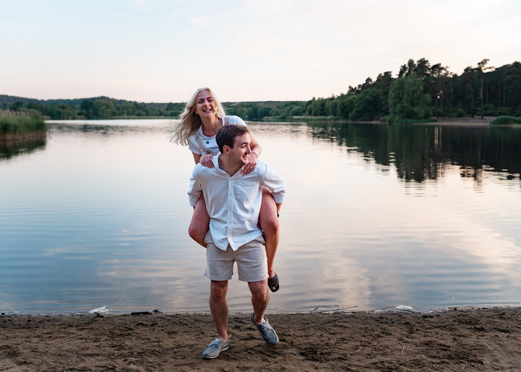 man gives his fiance a piggyback at photoshoot 