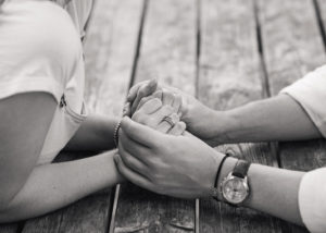 black and white image of couple holding hands 