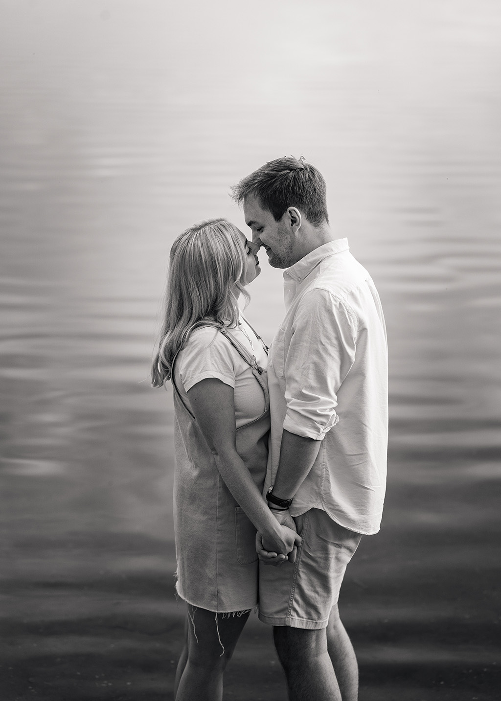 couple kissing in black and white in a lake 