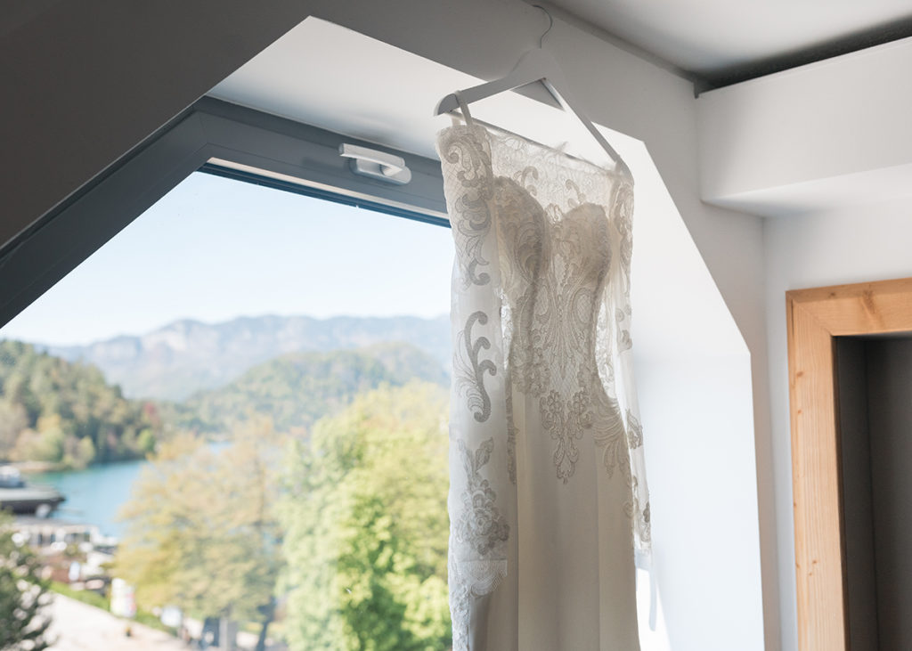 Dress hanging in front of window, showing lake bled island and castle