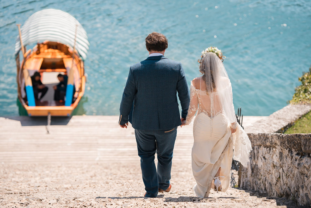 Bride and Groom walk down 99 steps on lake bled island wedding, to Pletna boat