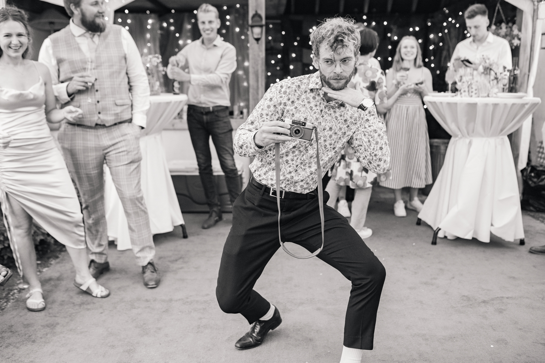 wedding guest strikes a pose with a film camera in his hand