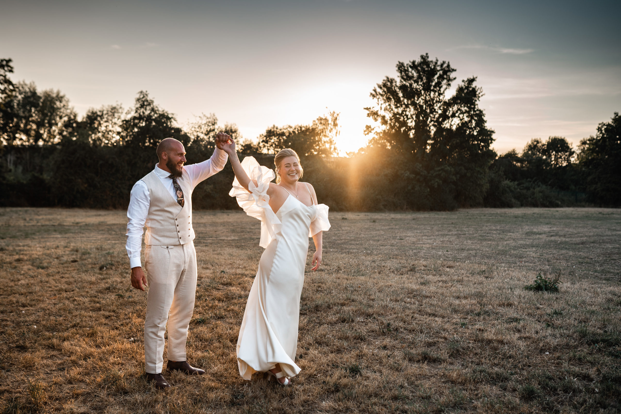 bride and groom dance with sunflares behind them in oxford