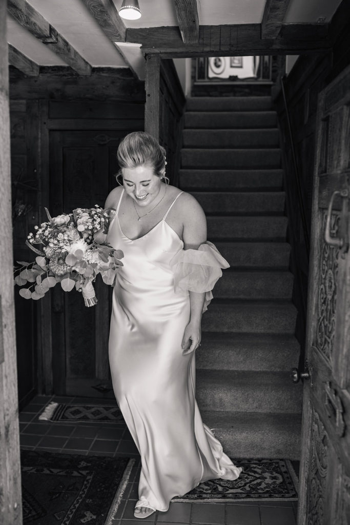 bride walking down stairs in country cottage wearing half penny london slip wedding dress