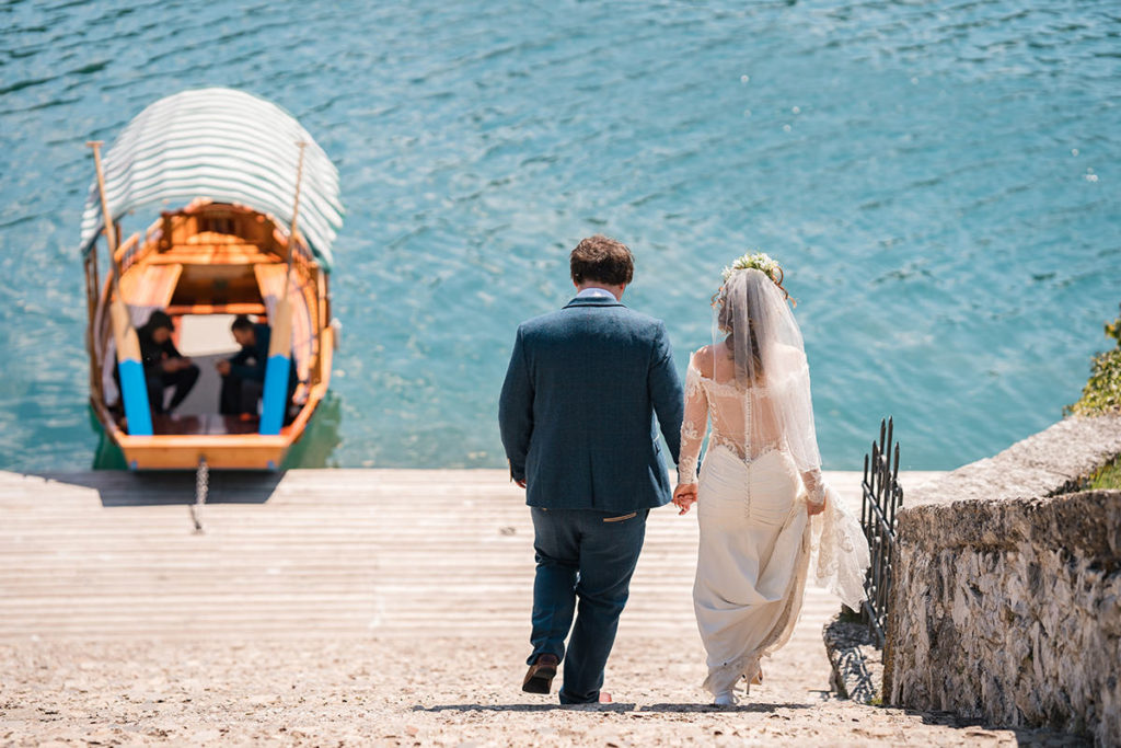 Lake bled wedding, couple walk down 99 steps towards the boats