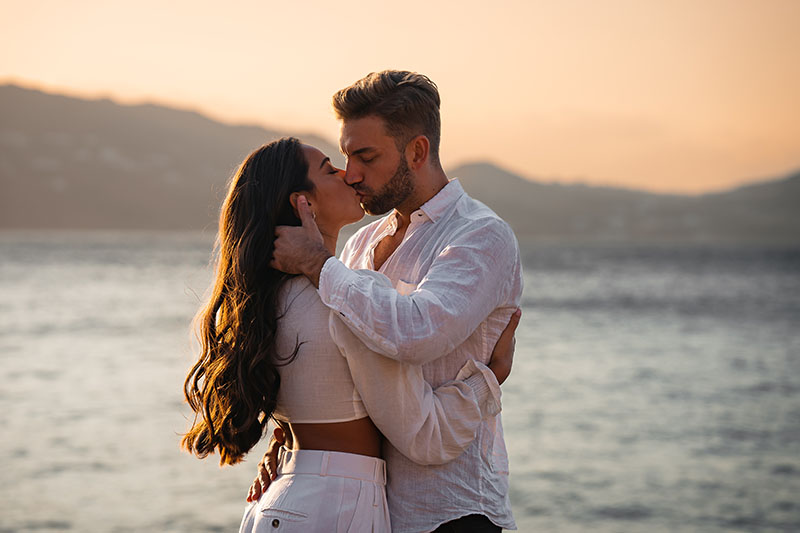 couple kiss at beach engagement shoot in mykonos