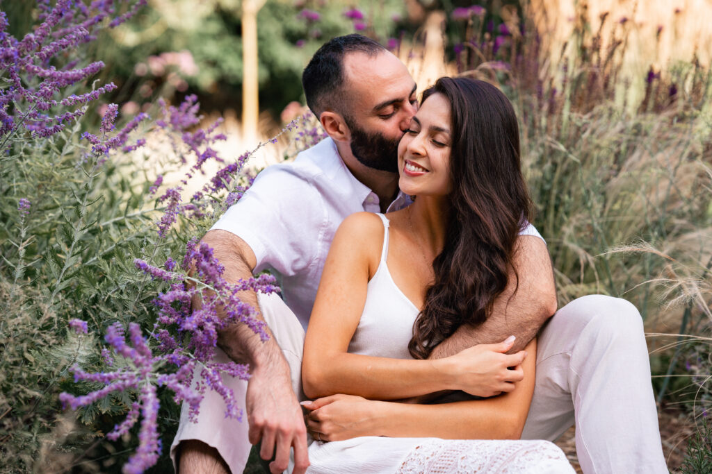 couple sit in Richmond flower garden at London Engagement session