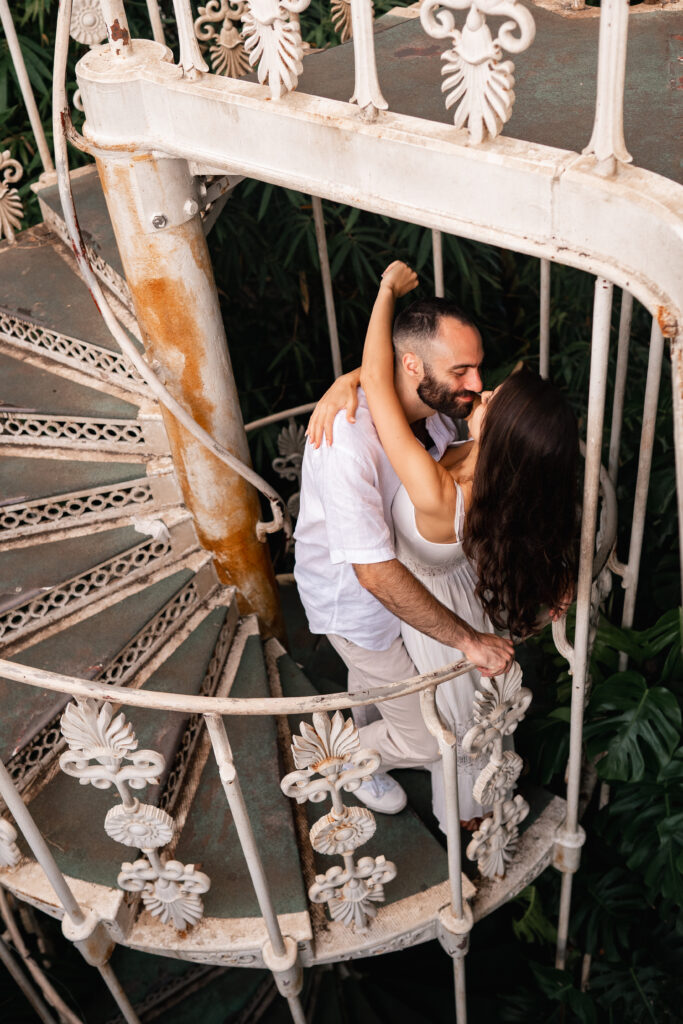 engaged couple on the spiral staircase inside KEW Gardens palm house