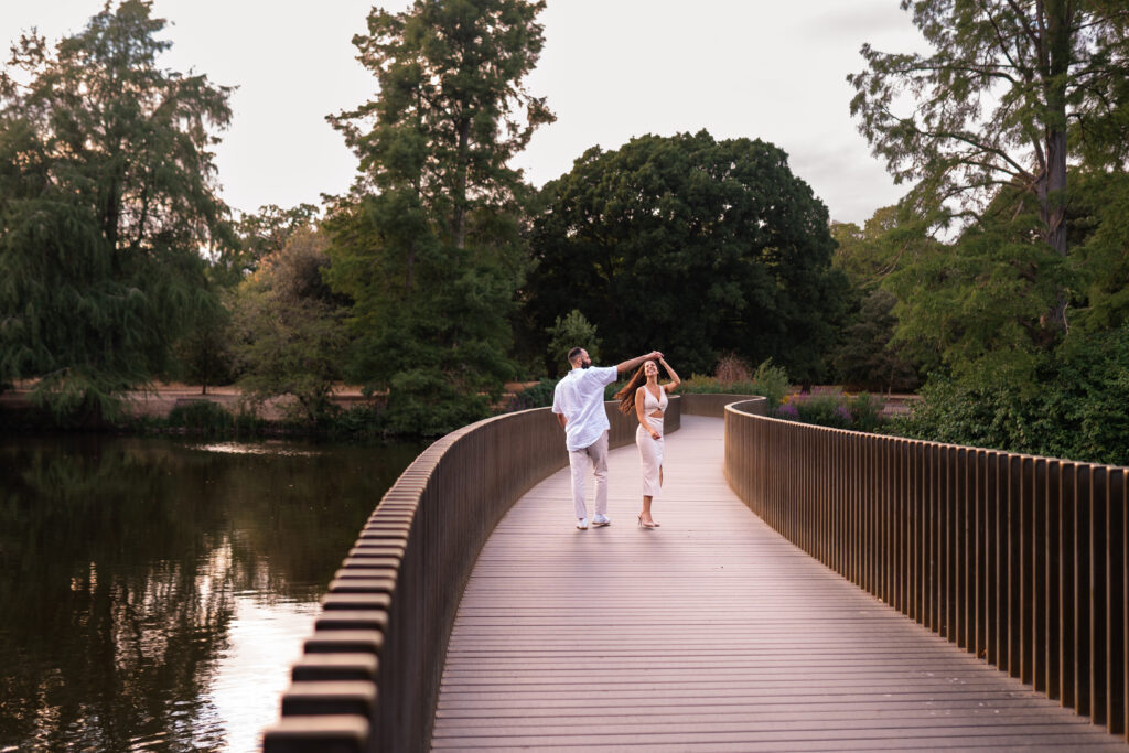 Couple cuddle on bridge at KEW Gardens at engagement photoshoot