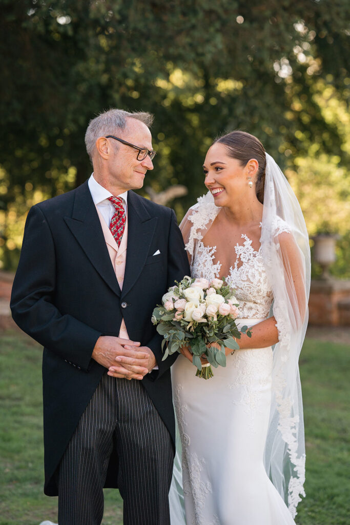 Bride arm in arm with father in tails at Chewton Glen wedding