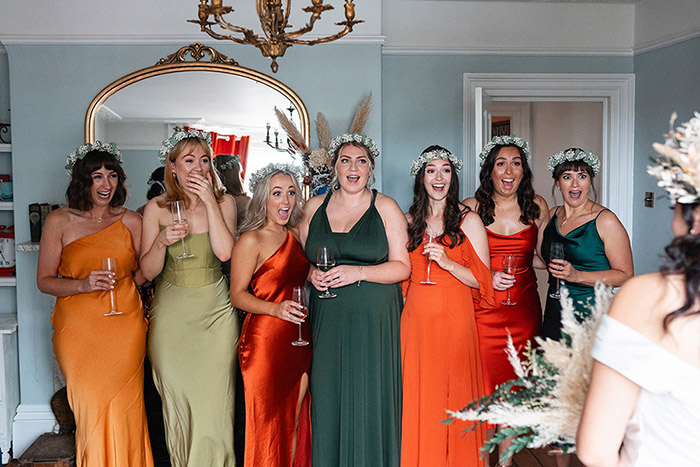 bridesmaids in jewel coloured dresses gasp and cry seeing bride for the first time