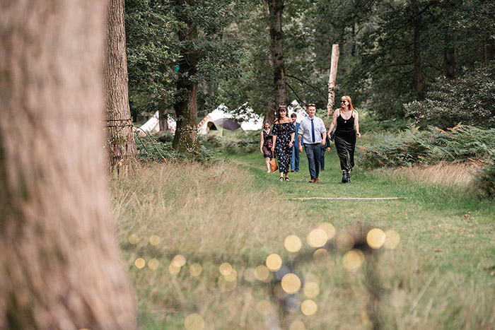 guests walking through harewood forest towards wedding ceremony