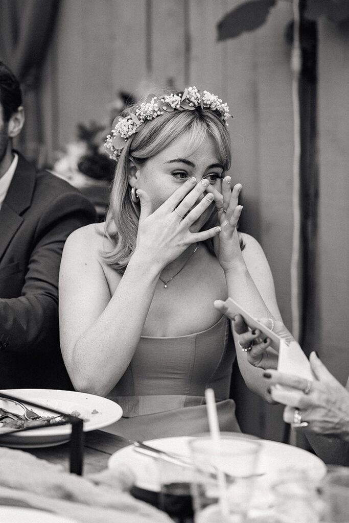 family member brushes away her tears during wedding speeches, emotional wedding photos