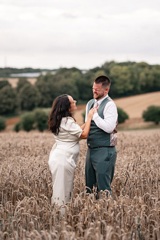 newly wed couple walking through wheat field