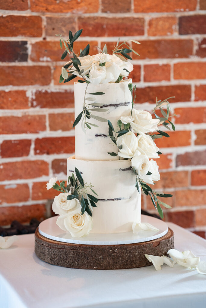 White naked wedding cake with fresh white flowers