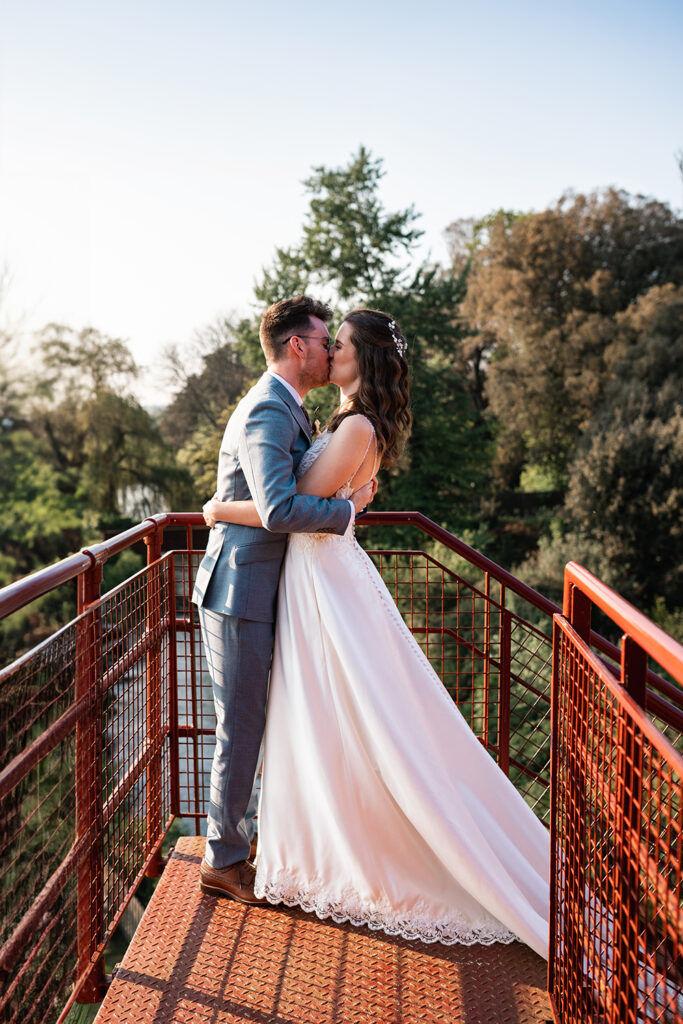 Bride and groom Kiss on the red fire escape at Sopley Mill
