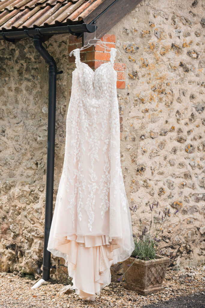 Lace dress hanging from barn exterior at Gorwell Farm wedding