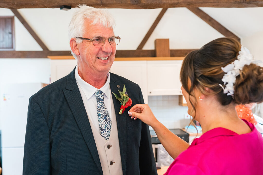 Bride helping dad with button hole on wedding morning