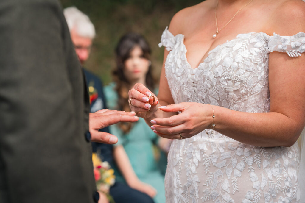 close up of ring as bride places it on her grooms hand