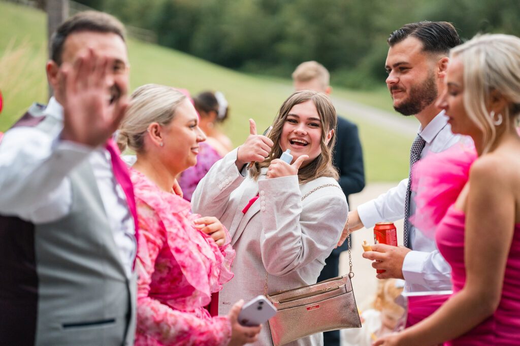 guests wave and give thumbs up to wedding photographer at Gorwell Farm