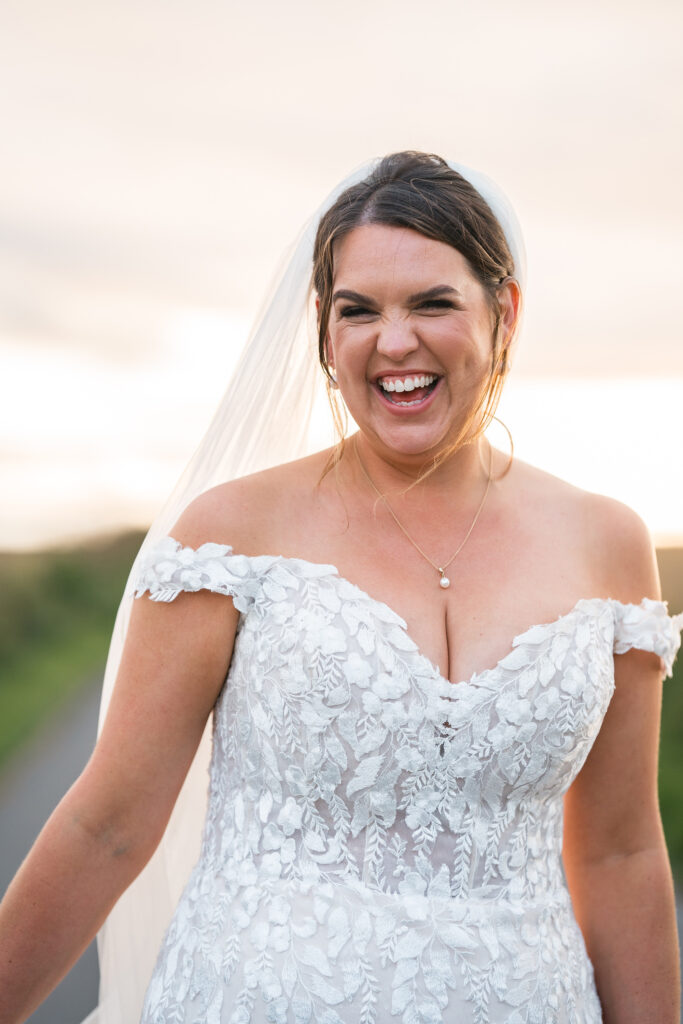 bride in lace sweetheart wedding dress smiles at camera at Gorwell Farm