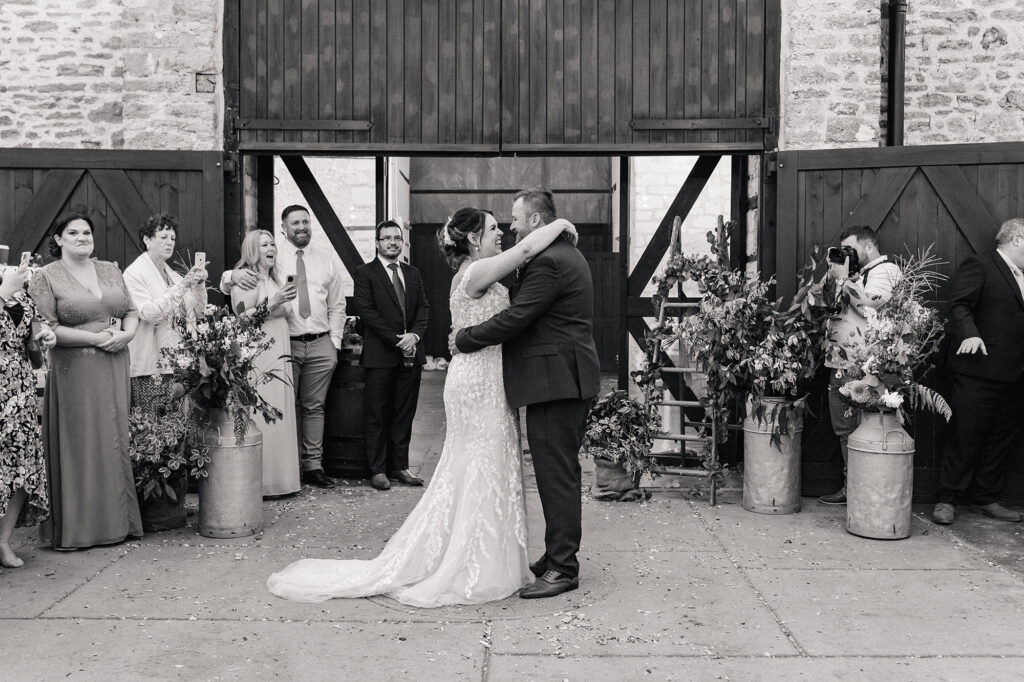 Black and White image of bride and groom having first dance in the courtyard at Gorwell Farm Wedding