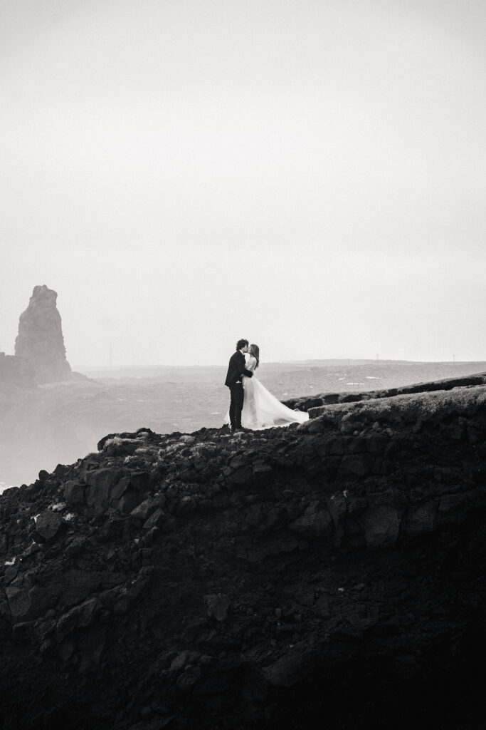 bride and groom dance on cliff top during iceland elopement