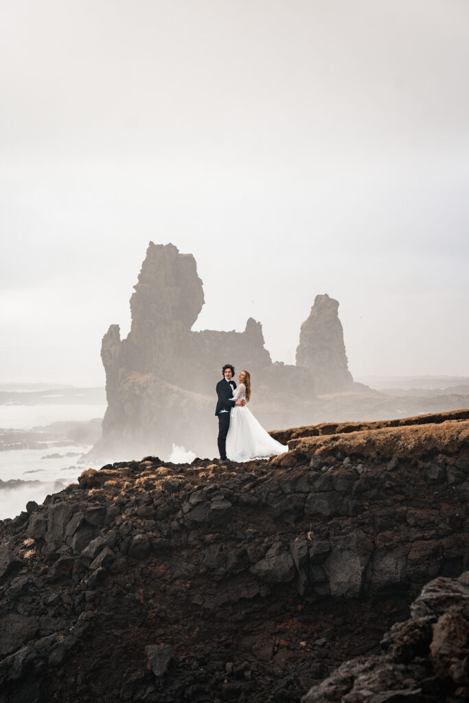 bride and groom dance on cliff top during iceland elopement