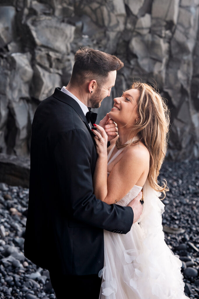 newly wed couple kiss on famous Black Beach Iceland