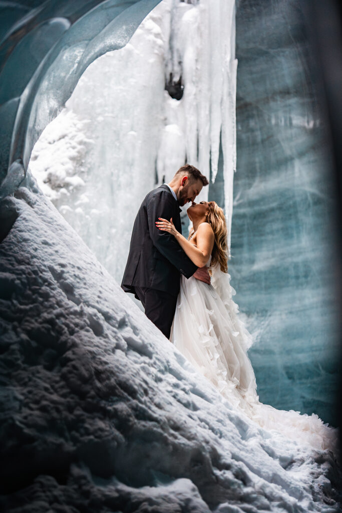 Newly married couple stand in ice cave in Icelands Glaciers