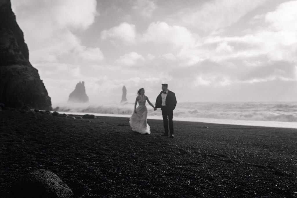 black and white image of couple on black sand beach wedding, iceland