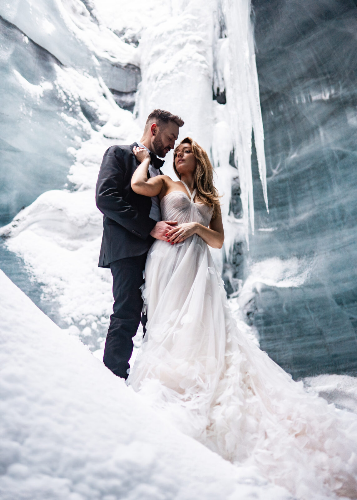 Newly married couple stand in ice cave in Icelands Glaciers