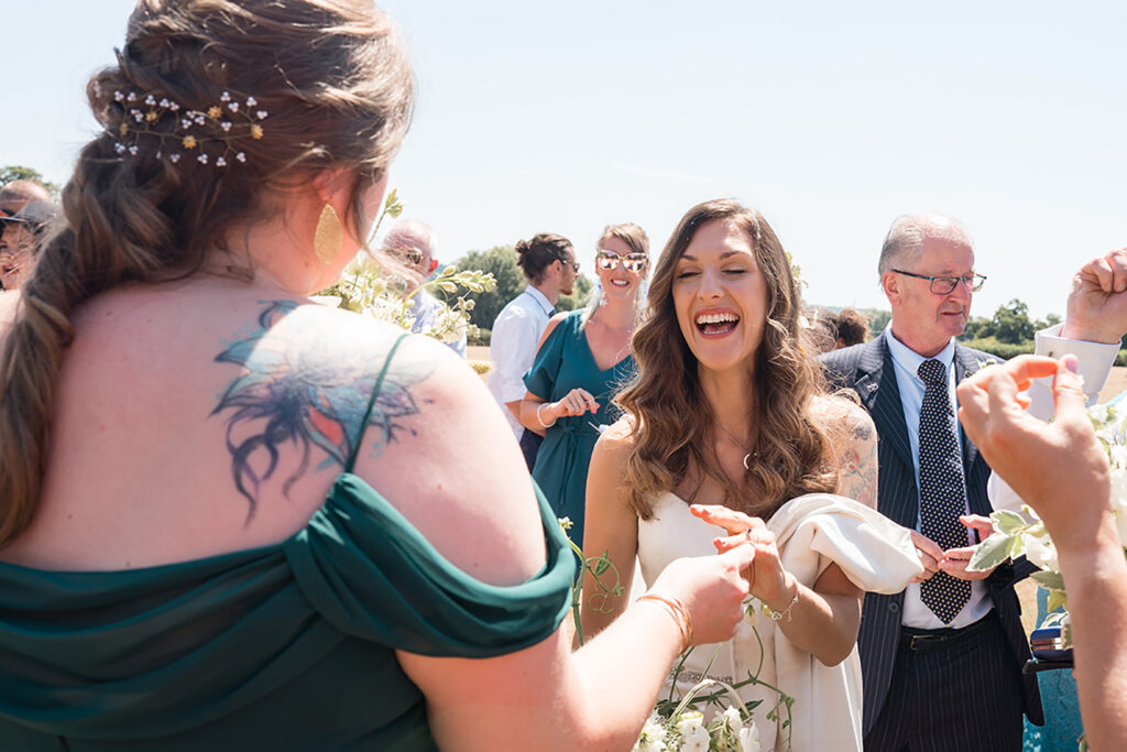 bride laughs with guest at outdoor new forest wedding