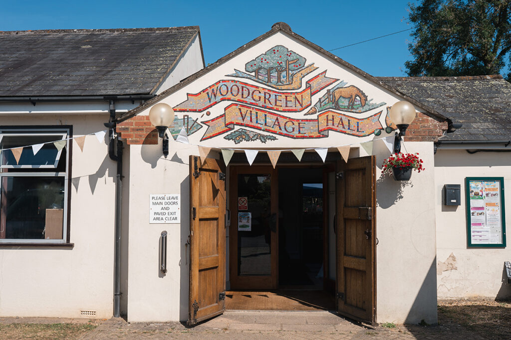 photo of the outside of new forest village hall, with bunting across the door