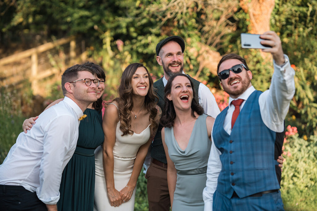 guests take a selfie with the bride at outdoor wedding