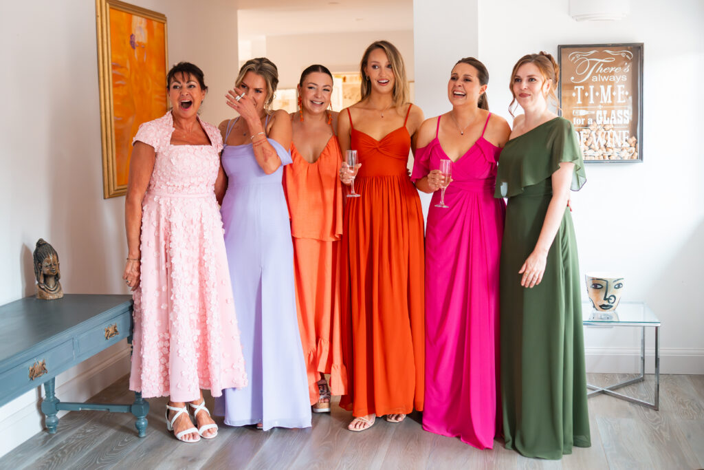 bridesmaids and mother of the bride cry as they see bride for first time