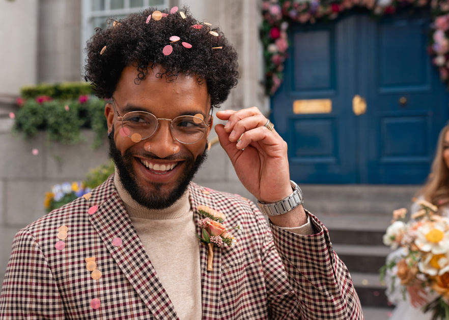 groom laughs and removes confetti from glasses