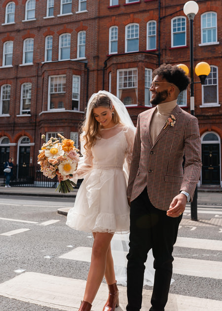 newly married couple walk through Chelsea hand in hand