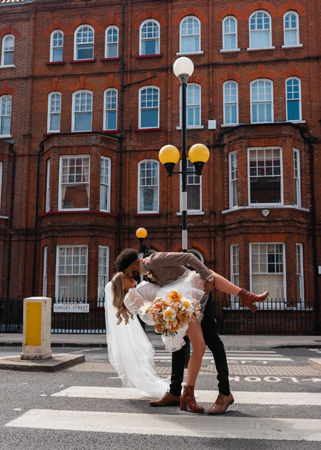 couple dip kiss at crossing in Chelsea after London wedding