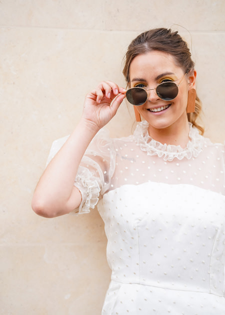 bride peers over sunglasses whilst smiling