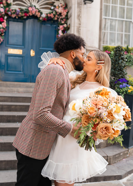 couple kiss on chelsea town hall steps after wedding