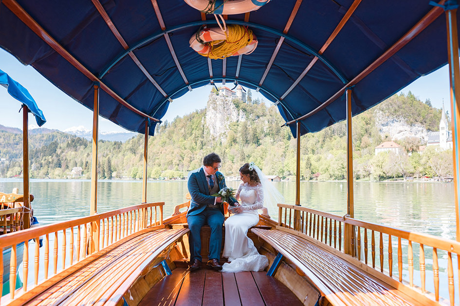 Bride and Groom sit in boat on way to Lake Bled wedding ceremony