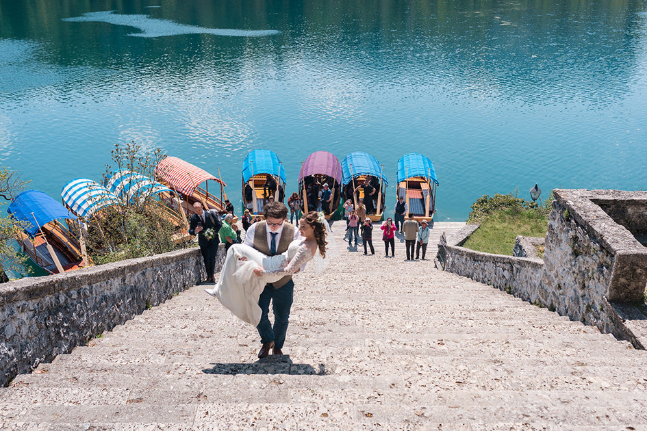 Groom carries bride up 99 steps at Lake Bled Wedding